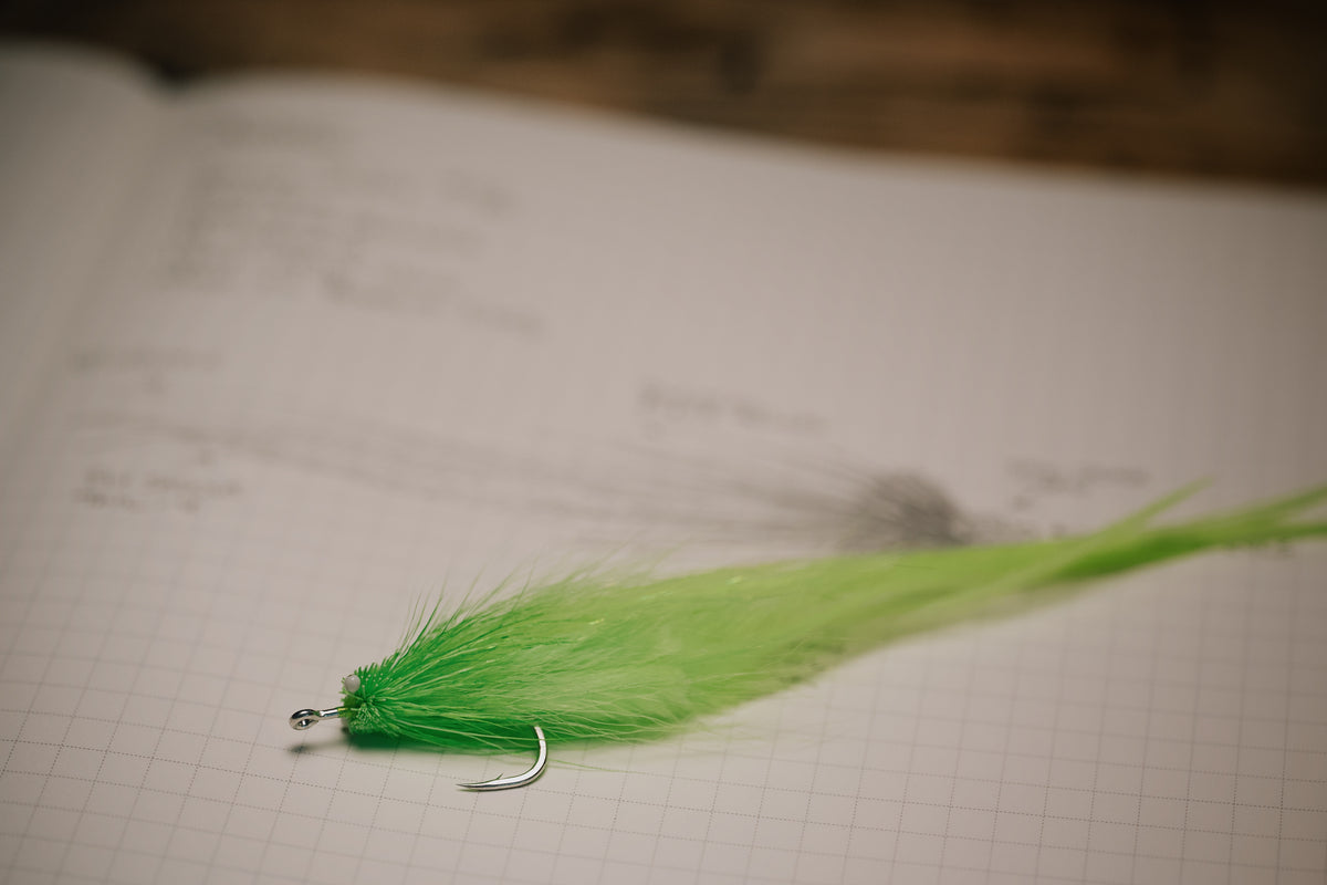a close up photo of the Snake tarpon fly lying on it’s corresponding page in my tying journal