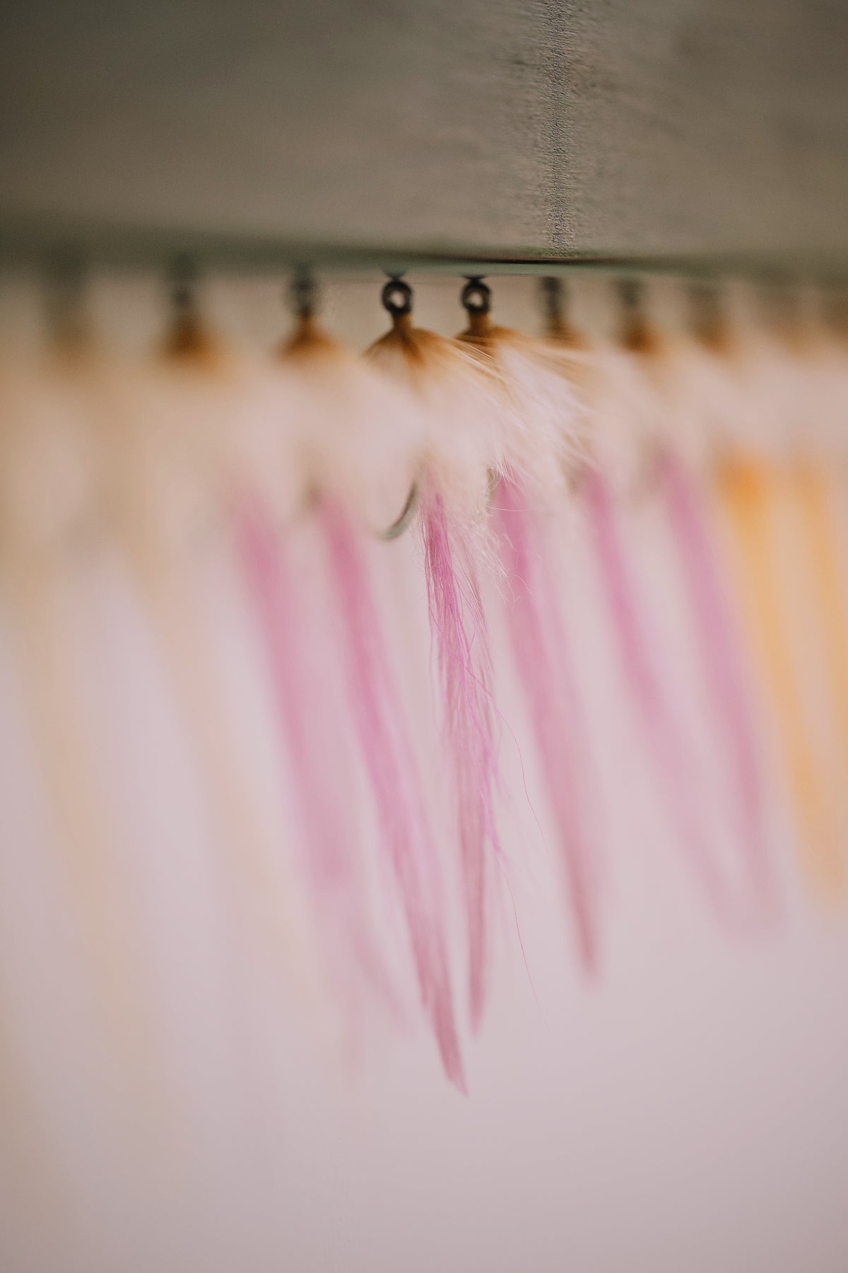 a colorful group of the Worm tarpon flies from Two Aught Fly Fishing Co hanging on my drying rack ready to ship